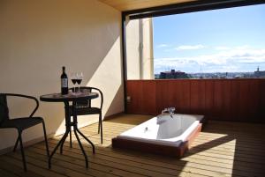a bath tub sitting on top of a balcony with a table at HOTELウォーターゲート蟹江（カップル専用） in Kanie