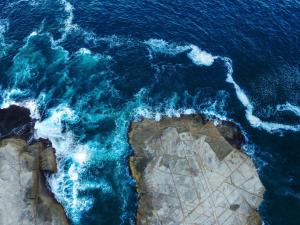 an aerial view of the ocean and the rocks at Surf Lodge Avoca Beach Waterfront to Avoca Lake in Avoca Beach
