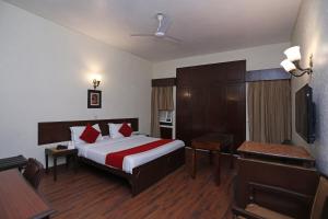 Cette chambre comprend un lit et un bureau. dans l'établissement Hamilton Hotel, à New Delhi