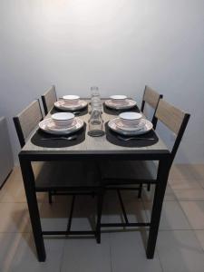 a black table with plates and dishes on it at One Spatial Condo in Iloilo City