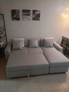 a couch in a living room with two pillows at One Spatial Condo in Iloilo City