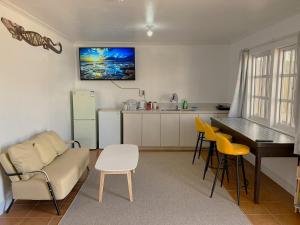 a living room with a couch and a table and a kitchen at YAJASU STAY Saipan in Saipan