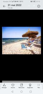 a picture of a beach with an umbrella and chairs at Résidence dunes du golf kantaoui in Sousse