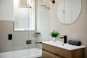 a bathroom with a sink and a shower and a mirror at Complete Host Cromwell Rd Apartments in Melbourne +5 photos