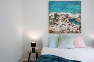 a bedroom with a bed and a painting on the wall at Complete Host Cromwell Rd Apartments in Melbourne