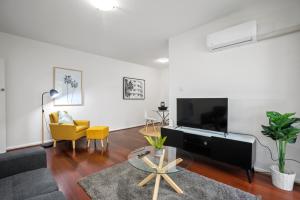 a living room with a large flat screen tv at Complete Host Cromwell Rd Apartments in Melbourne