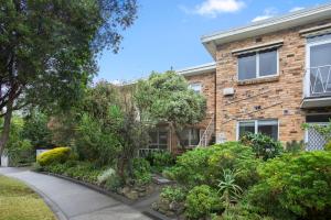 a brick building with a garden in front of it at Complete Host Cromwell Rd Apartments in Melbourne