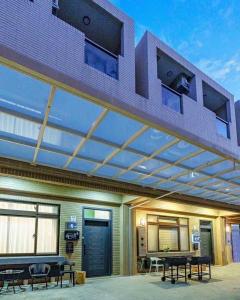 a patio with a roof with a table and benches at 咫尺民宿 in Wujie