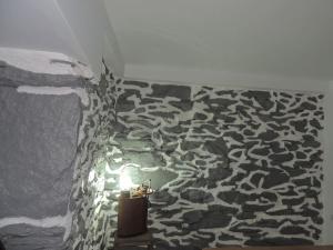 um quarto com uma parede de pedra com uma vela em Casa do Forno F.R em Barreiro