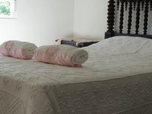 Una cama con dos almohadas encima. en Casa do Forno F.R, en Barreiro