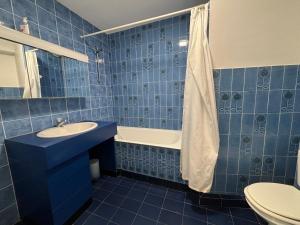 レ・サ​​ーブル・ドロンヌにあるStudio Les Sables-d'Olonne, 1 pièce, 2 personnes - FR-1-197-242の青いタイル張りのバスルーム(シンク、バスタブ付)