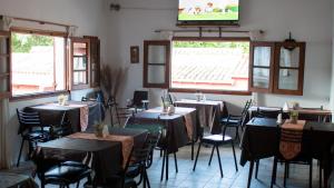 une salle à manger avec des tables, des chaises et une télévision dans l'établissement Los Manantiales, à Tanti