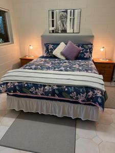 Un dormitorio con una cama grande con flores. en The singing frogs studio en Coffs Harbour