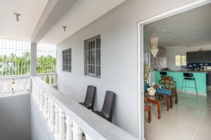 a balcony with chairs and a kitchen in a house at Casa cerca SDQ & Bus Caribe tours in Santo Domingo
