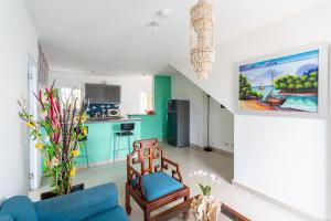 a living room with a blue couch and a kitchen at Casa cerca SDQ & Bus Caribe tours in Santo Domingo