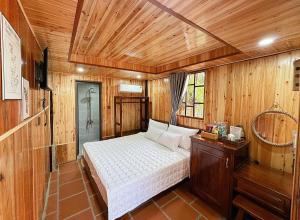 een slaapkamer met een bed in een houten kamer bij Kara Homestay & Cafe in Can Tho