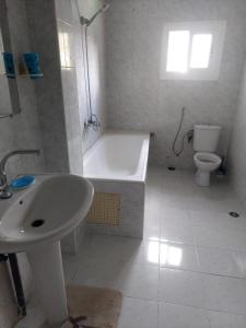 a bathroom with a tub and a sink and a toilet at Himmich in Asilah