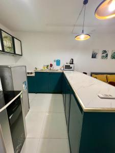 a kitchen with green cabinets and a white counter top at Maison Bùi Viện in Ho Chi Minh City