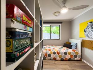 - une chambre pour enfants avec un lit et une étagère à livres dans l'établissement Shailer Park Serenity, à Tanah Merah