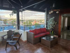 a living room with a red couch on a balcony at Rooftop Paradise in San Francisco de Macorís