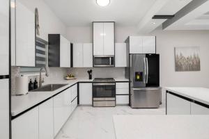 une cuisine avec des armoires blanches et des appareils en acier inoxydable dans l'établissement Quinta Real 4905, à McAllen