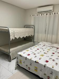 um quarto com uma cama e um beliche com uma cama quadrada em Casa com piscina e churrasqueira em Bonito