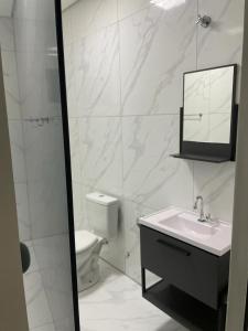 a bathroom with a toilet and a sink and a mirror at Casa com piscina e churrasqueira in Bonito