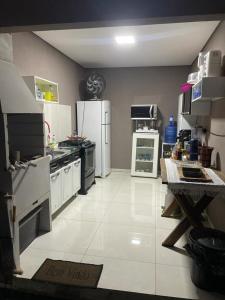 a kitchen with white appliances and a white floor at Casa com piscina e churrasqueira in Bonito