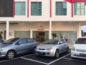 tres autos estacionados en un estacionamiento frente a un edificio en Hotel Mirage PD, en Port Dickson