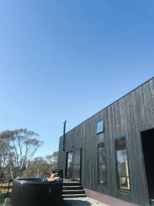 a house with a pool in front of it at Common Kosci - luxury bespoke cabin in the Snowies in Jindabyne
