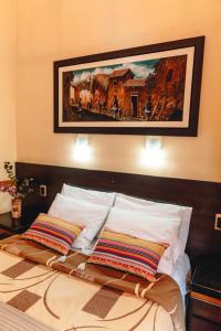 un letto con due cuscini e un dipinto sul muro di Qosqo Wasi a Cuzco