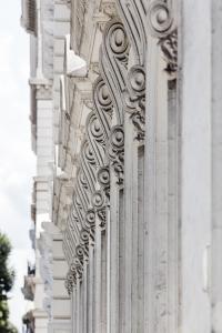 a white building with a bunch of columns on it at The Queens Gate Hotel in London