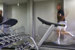 a person running on a treadmill in a gym at The Queens Gate Hotel in London