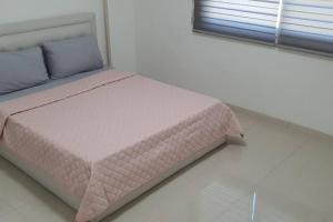 1 dormitorio con 1 cama rosa en una habitación blanca en Toma suite 2 bed rooms, en Clark