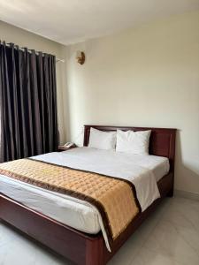 a bedroom with a large bed with a wooden headboard at Hoàng Khiêm Hotel in Mỹ Thạch