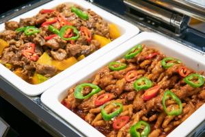 two styrofoam containers of food with peppers on them at Elephant Hotel in Zhuhai