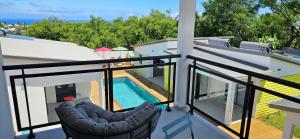 un balcón con 2 sillas y una piscina en Paradise City Break en San Pedro