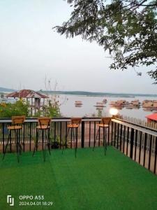 una terraza con sillas y vistas al agua en บ้านระเบียงน้ำวังใหญ่ วังสามหมอ อุดร, en Wang Sam Mo