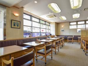 un comedor con mesas, sillas y ventanas en Yokkaichi City Hotel Annex, en Yokkaichi