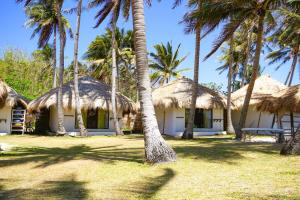 um grupo de cabanas com palmeiras em frente em Private Beachescape - Amansinaya Beachhouse Mindoro em Bulalakao