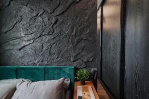 a bedroom with a green headboard and a stone wall at Oceanview Apartment baltyk Gdynia in Gdynia