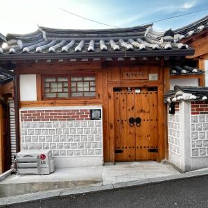 una casa con una porta in legno e un cancello di Hwadong 1Beonji a Seul
