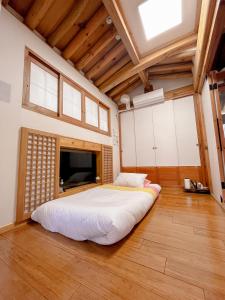uma cama grande num quarto grande com tectos em madeira em Hwadong 1Beonji em Seul