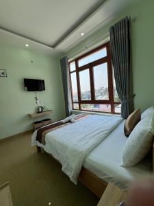 um quarto com uma cama grande e uma janela em Alex Home Đà Lạt em Da Lat