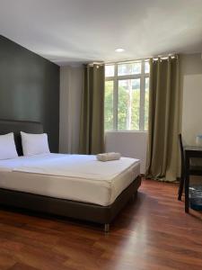 um quarto com uma cama, uma mesa e uma janela em 1st inn hotel subang em Subang Jaya