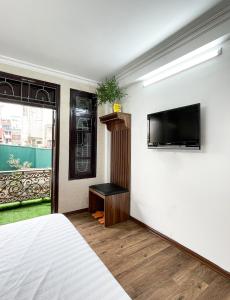 a bedroom with a bed and a tv on a wall at Hanoi Oriental Viewl Hotel in Hanoi