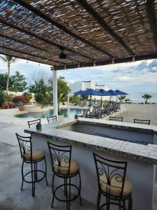 un bar con sedie e ombrelloni accanto alla piscina di Poseidons Cove Private Home Vacation Rental a San José del Cabo