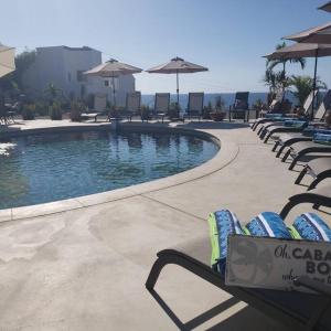una piscina con lettini e ombrelloni di Poseidons Cove Private Home Vacation Rental a San José del Cabo