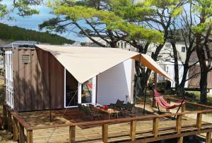 een tiny house op een terras met een tent bij Mineyama Kogen Hotel Relaxia in Kamikawa