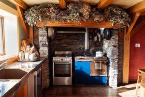 a kitchen with a stove and a stone wall at housewithnonails in Matamata